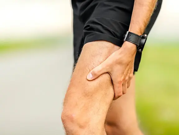 Typische Beschwerden bei belastungsbedingter Arthrose: Schmerzen, Steifigkeit und geringere Belastbarkeit. Mann leidet an Gelenksteifigkeit und eingeschränkter Belastbarkeit aufgrund einer belastungsbedingten Arthrose im Knie.